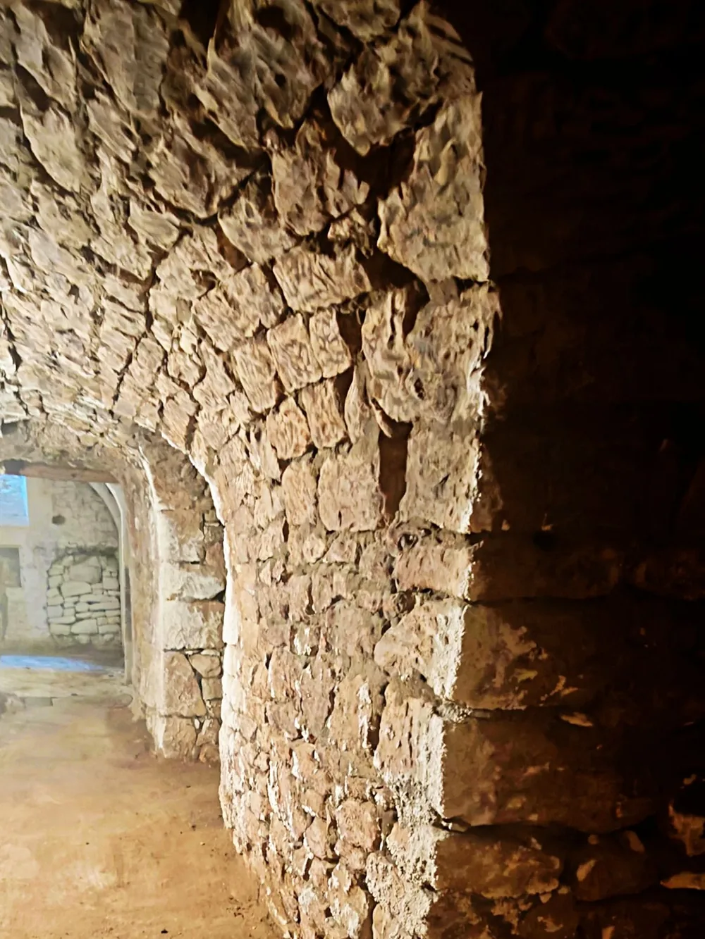 Galerie voûtée en pierre sèche dans les caves du manoir